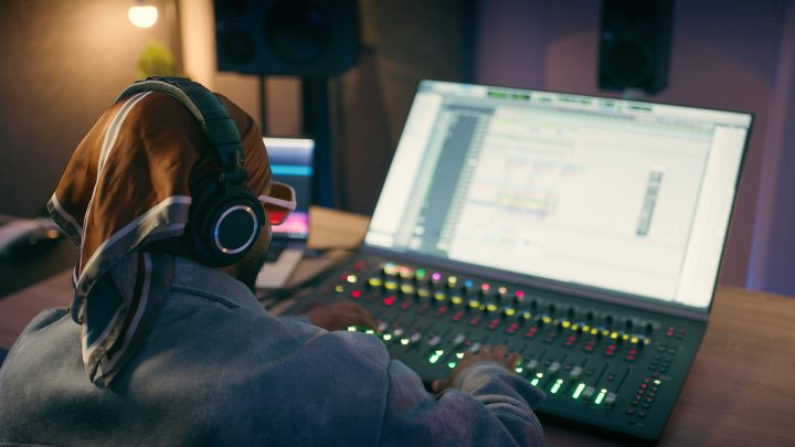 Screen, engineer and sound with back of person for music production, audio editor and project. Mixing console, media label and broadcast board with producer in recording studio for song deck